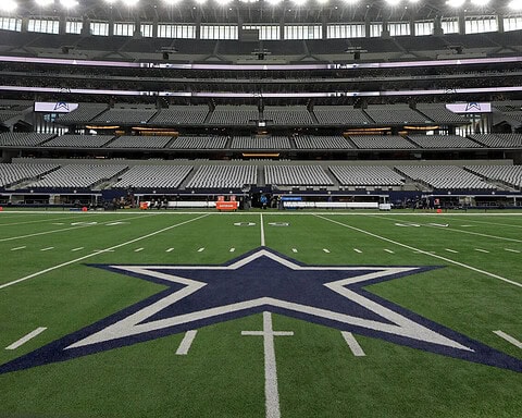 Empty Dallas Cowboys football stadium with the iconic star logo on the field, ready for a game, inside AT&T Stadium in Dallas, Texas.