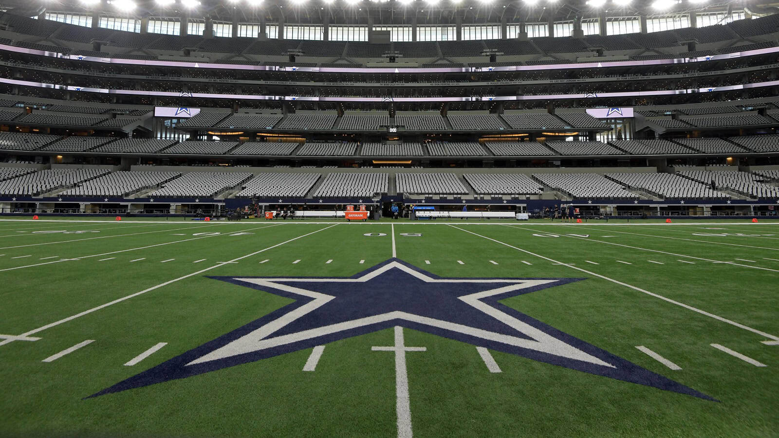 Empty Dallas Cowboys football stadium with the iconic star logo on the field, ready for a game, inside AT&T Stadium in Dallas, Texas.