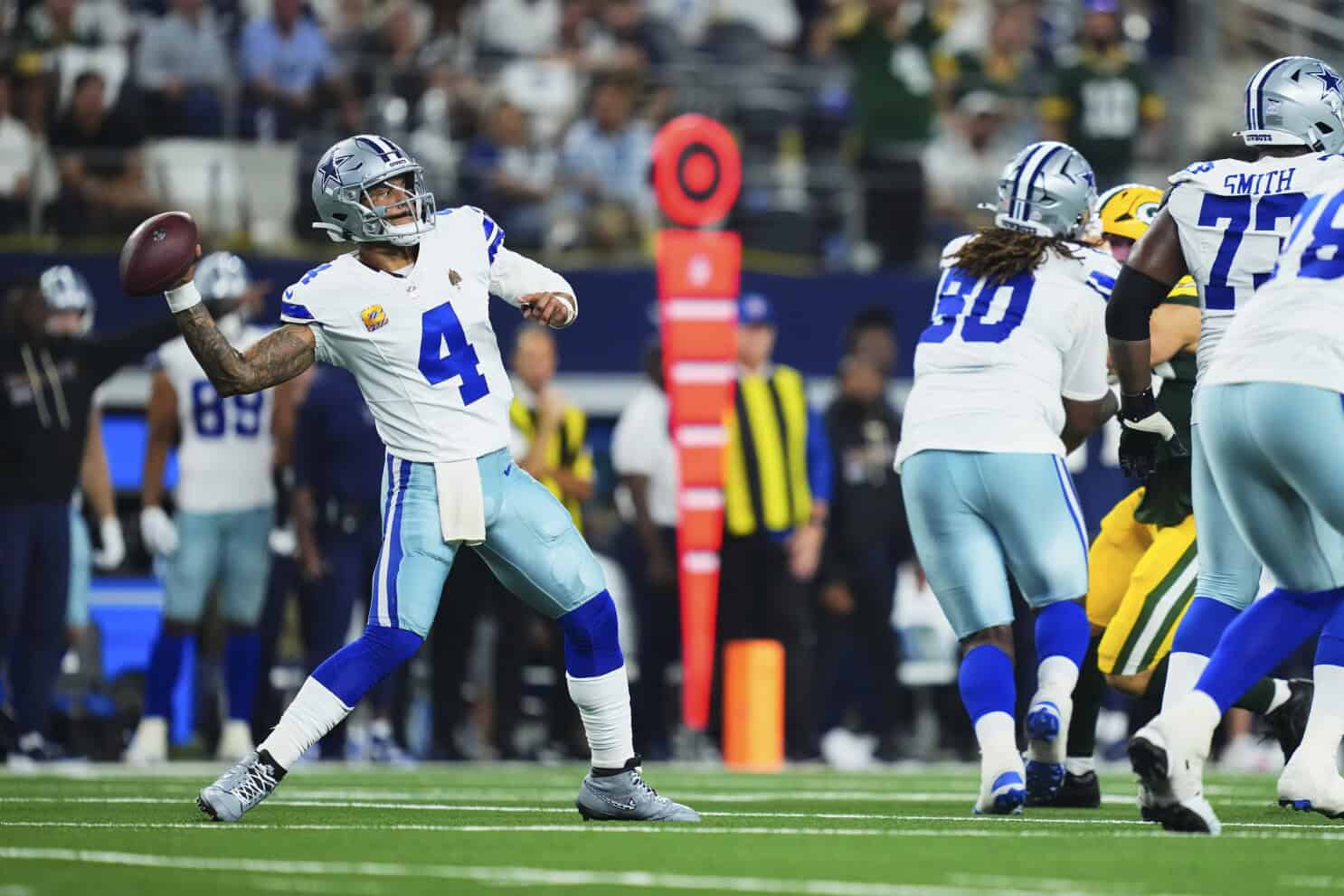 Quarterback Dak Prescott of the Dallas Cowboys prepares to throw a pass during an NFL game, showcasing team strategy and athletic performance on the football field.