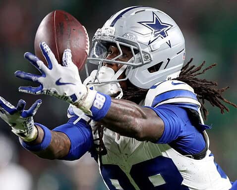 CeeDee Lamb of the Dallas Cowboys catching a football during an NFL game, showcasing his athleticism, skill, and focus on the field. Inside The Star provides expert analysis of Cowboys' players and games.
