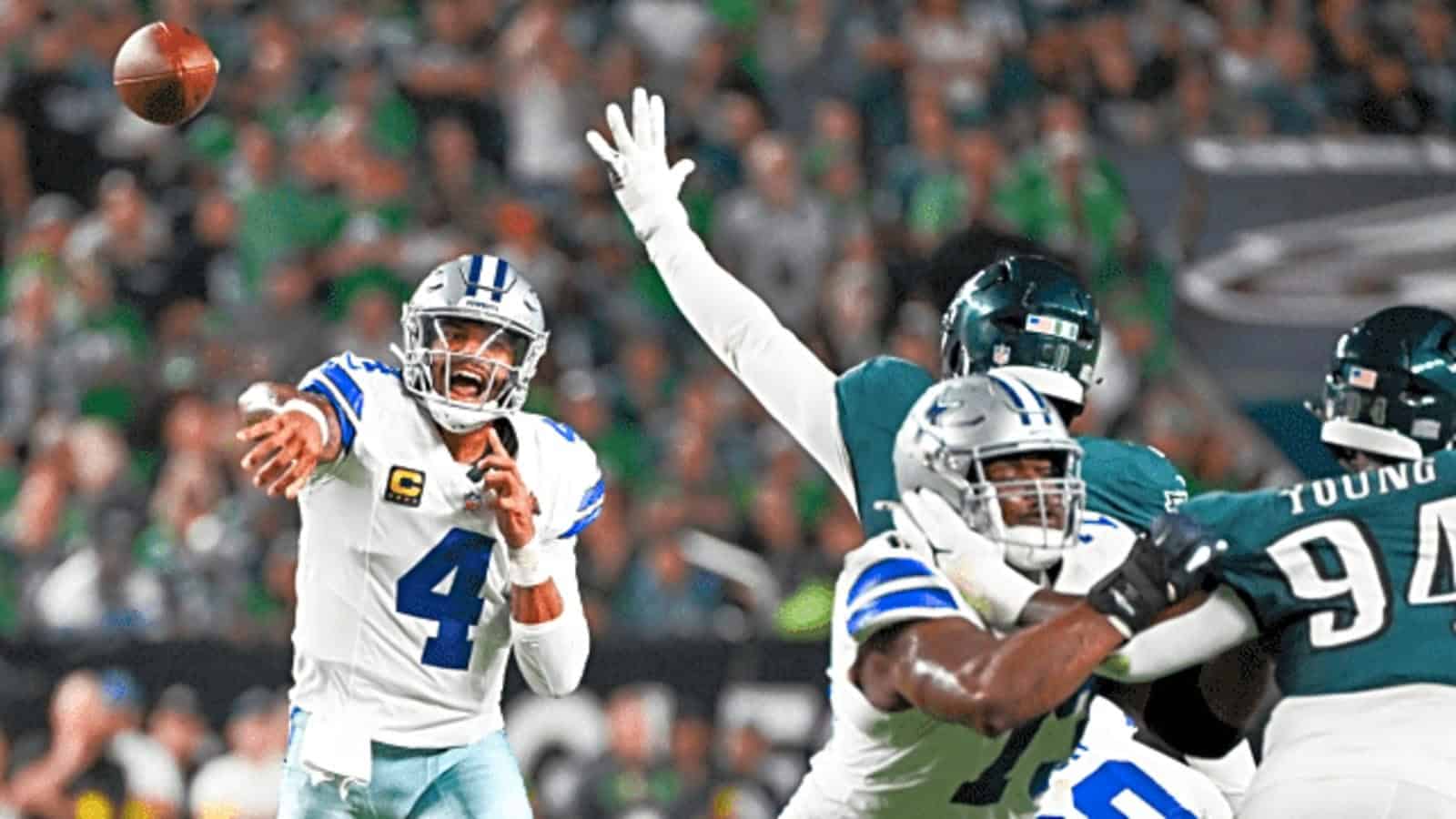 Quarterback Dak Prescott throwing a pass during an NFL game with Dallas Cowboys, with defensive players from the Philadelphia Eagles attempting to intercept, on a vibrant football field.
