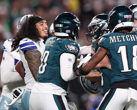 - NFL football players celebrating on the field, Dallas Cowboys vs. Philadelphia Eagles game, showing team spirit and football rivalry, inside the star stadium.