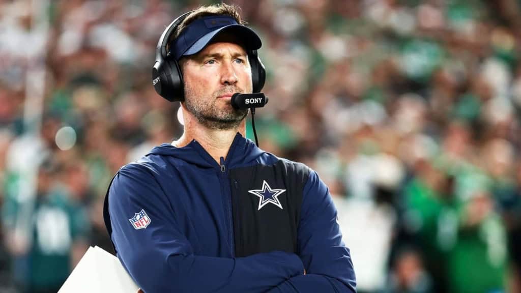 Head coach with headset at football game, Dallas Cowboys insider, wearing team jacket and cap, focused on game strategy, NFL football team, Inside The Star coverage, sports coaching.
