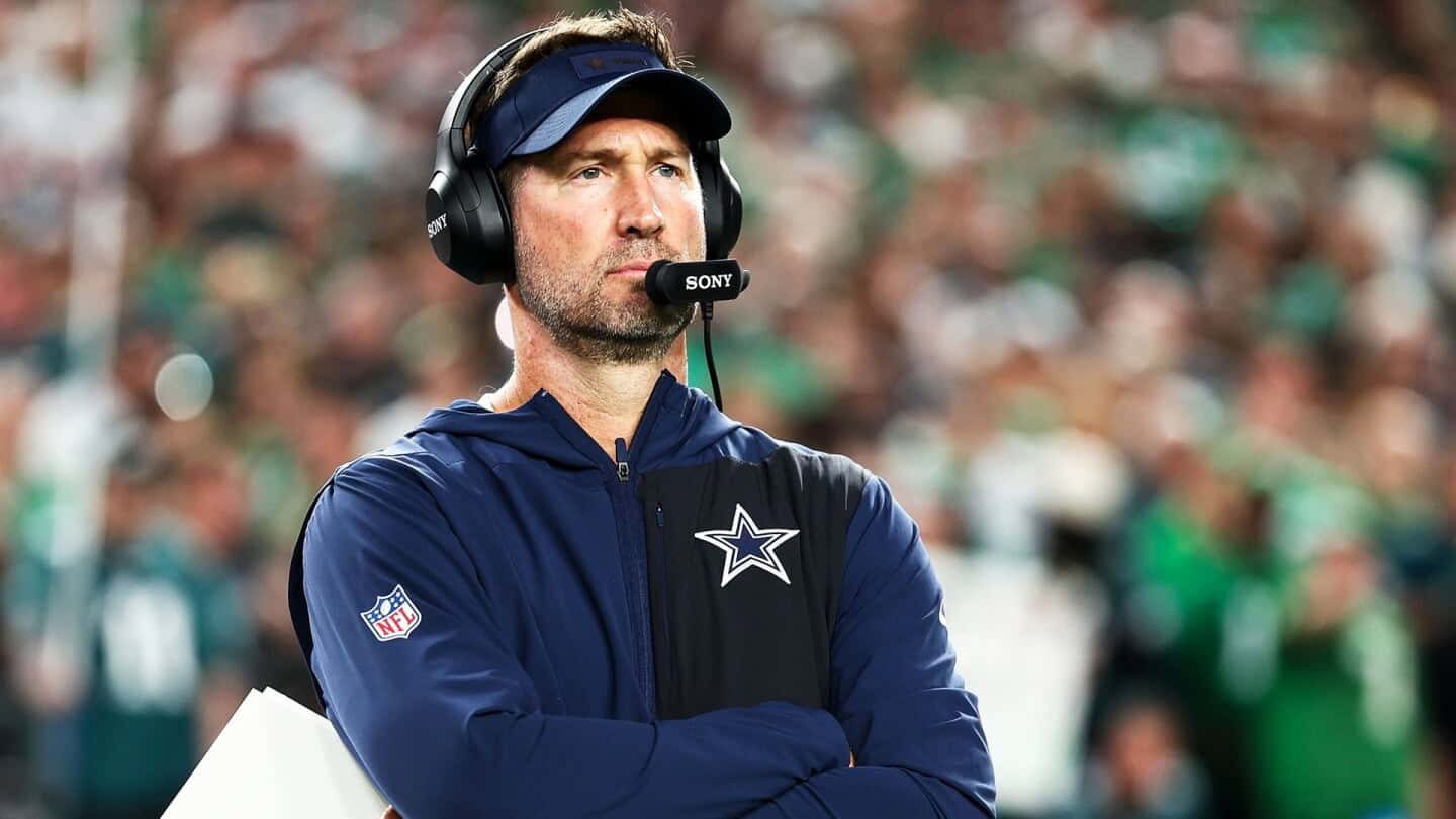 Head coach with headset at football game, Dallas Cowboys insider, wearing team jacket and cap, focused on game strategy, NFL football team, Inside The Star coverage, sports coaching.