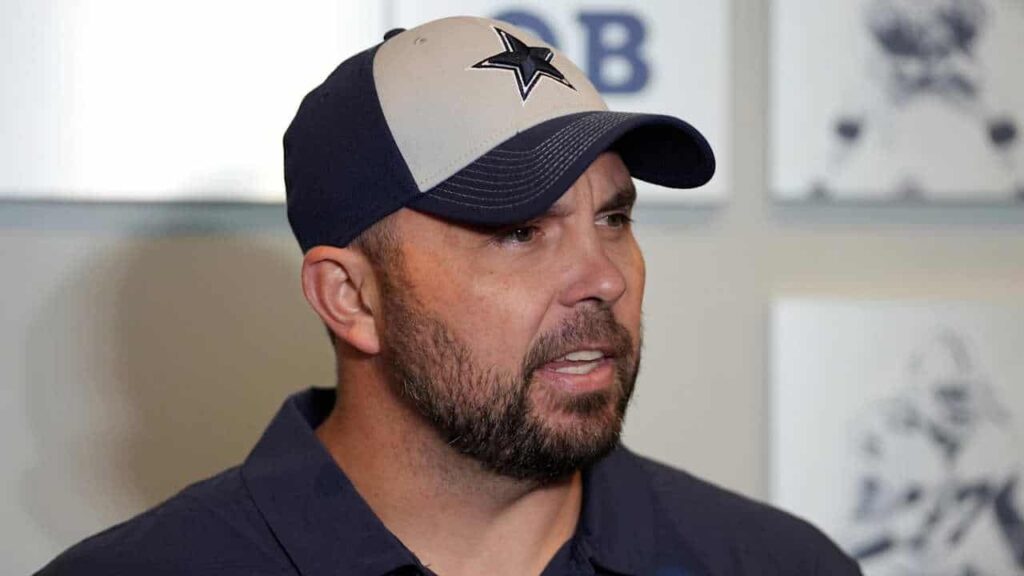 Dallas Cowboys coach wearing team cap featuring star logo, speaking during interview at Inside The Star.