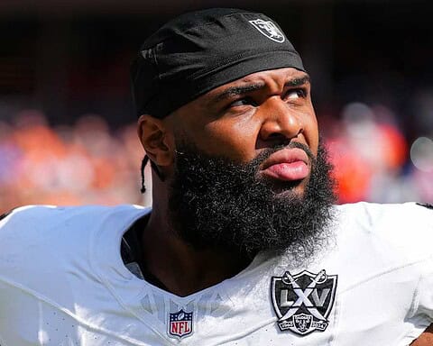 Professional football player wearing Dallas Cowboys uniform, sporting a black headband and beard, during an NFL game, highlighting Inside The Star Dallas Cowboys coverage.