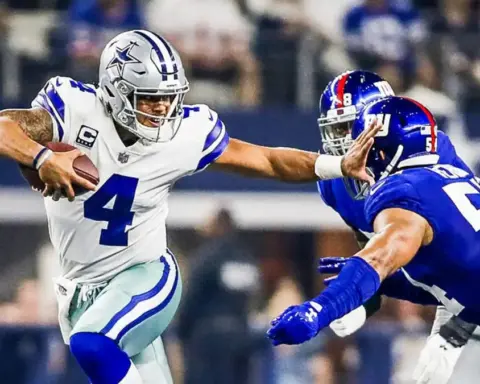 Dynamic NFC East football game featuring Dallas Cowboys quarterback Dak Prescott evading defensive players during an intense NFL match at AT&T Stadium.
