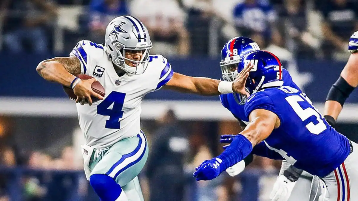 Dynamic NFC East football game featuring Dallas Cowboys quarterback Dak Prescott evading defensive players during an intense NFL match at AT&T Stadium.