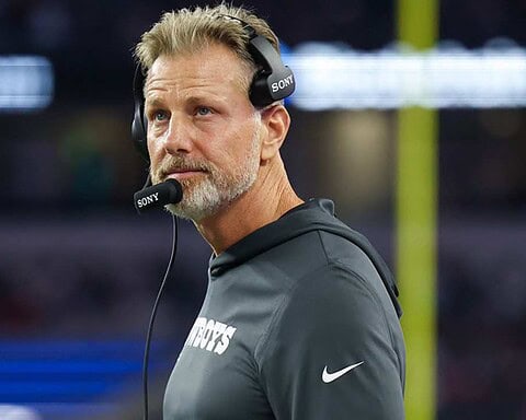 Head coach with headset on during an American football game at AT&T Stadium in Dallas.