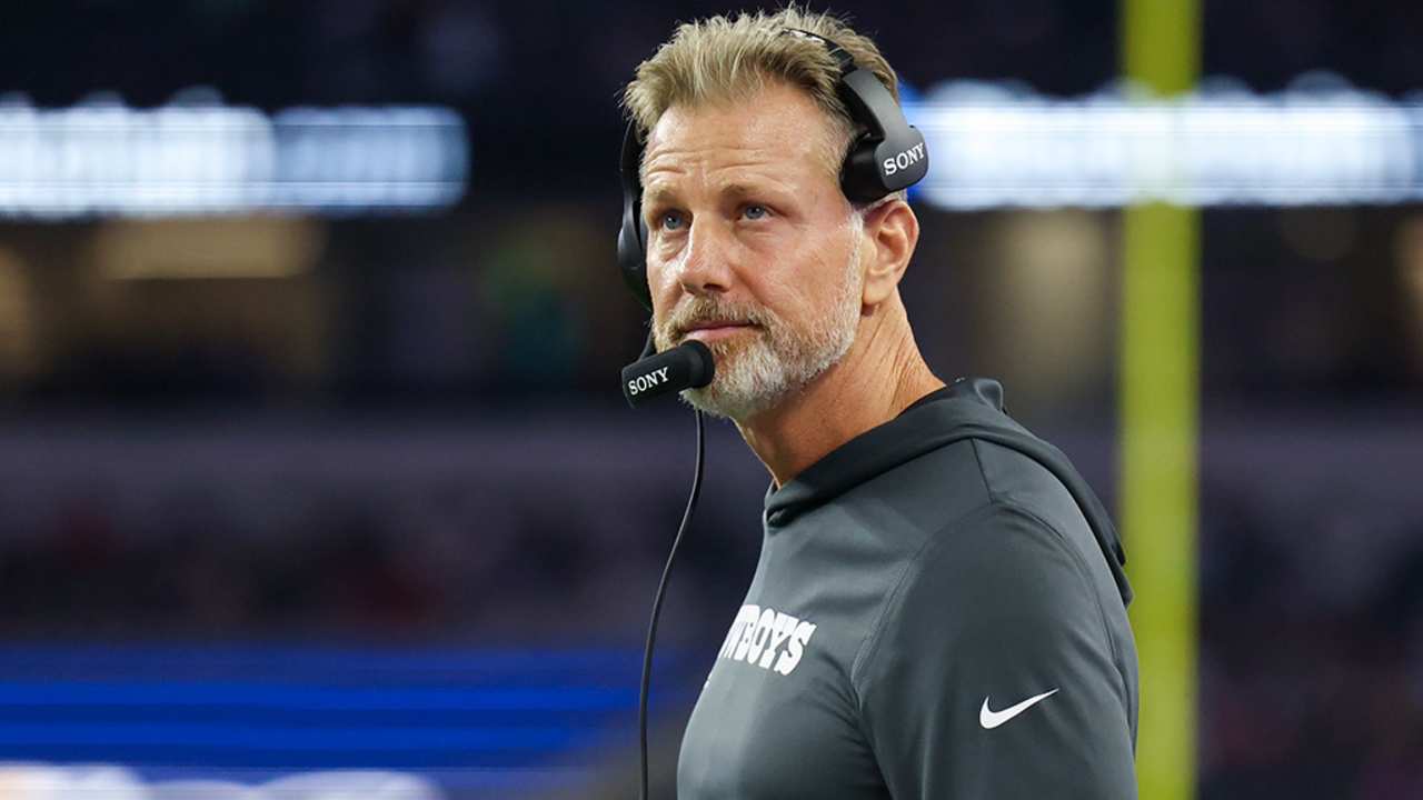 Head coach with headset on during an American football game at AT&T Stadium in Dallas.