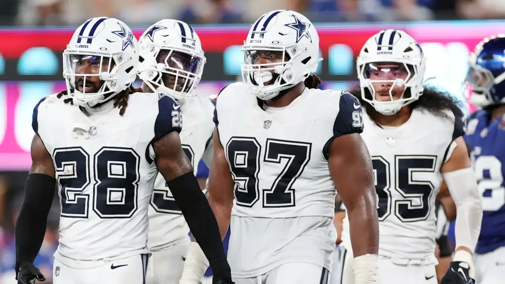 Dallas Cowboys football team players walking on field in game.