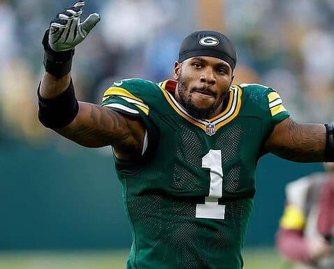 Ace of Green Bay Packers football player celebrating on the field during a game, wearing team uniform and gloves. Inside the Star logo and coverage of NFL and Green Bay Packers sports news.