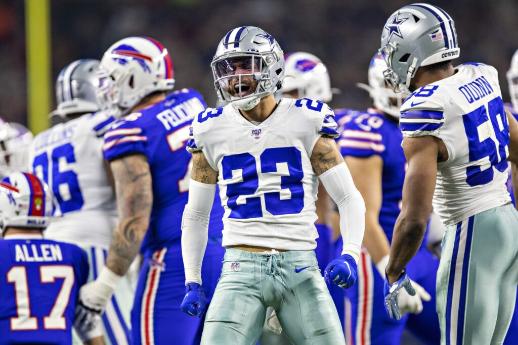 Dallas Cowboys football players celebrating during a game on the field during NFL season. Focus on player wearing jersey number 23 in a white and blue uniform.