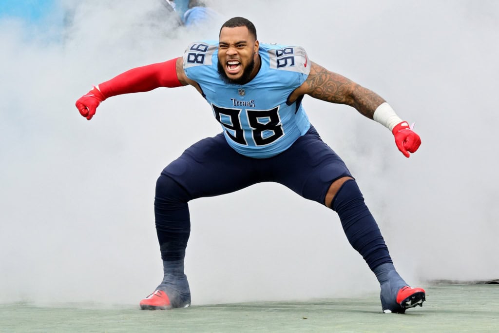 Aggressive Tennessee Titans football player in jersey number 98, flexing in a stadium with smoke, showcasing strength and team spirit, for Inside The Star SEO content.