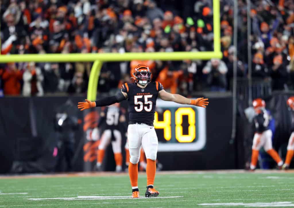 Celebrating a touchdown by Cincinnati Bengals linebacker number 55 in an NFL game at Paul Brown Stadium. The player is wearing a black jersey, orange gloves, and a helmet, with the scoreboard showing 40 seconds remaining. The intense game atmosphere includes a cheering crowd and team teammates in the background. This action shot highlights key moments in football, team spirit, and game-day excitement.