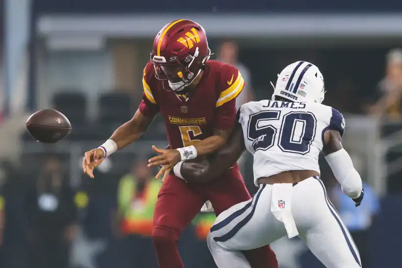 Quarterback throwing a football during an NFL game between Washington Commanders and Dallas Cowboys.