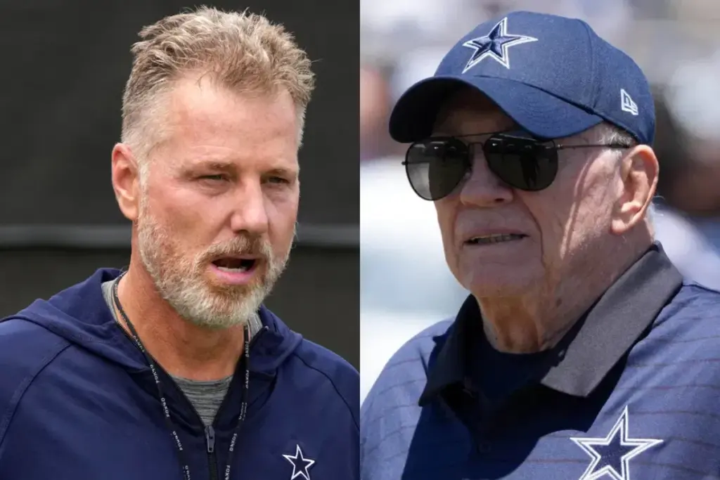 Dallas Cowboys football coach speaking during a game, wearing team gear and headset; veteran coach and young coach involved in Dallas Cowboys football team.