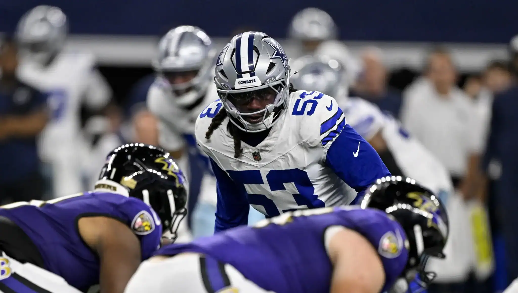 Dallas Cowboys football player in action during a game, wearing team uniform, helmet, and protective gear on the field.