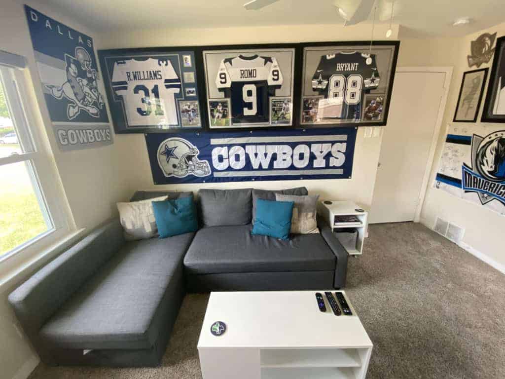 Dallas Cowboys memorabilia and decor featuring framed jerseys and team banners displayed in a sports-themed room.