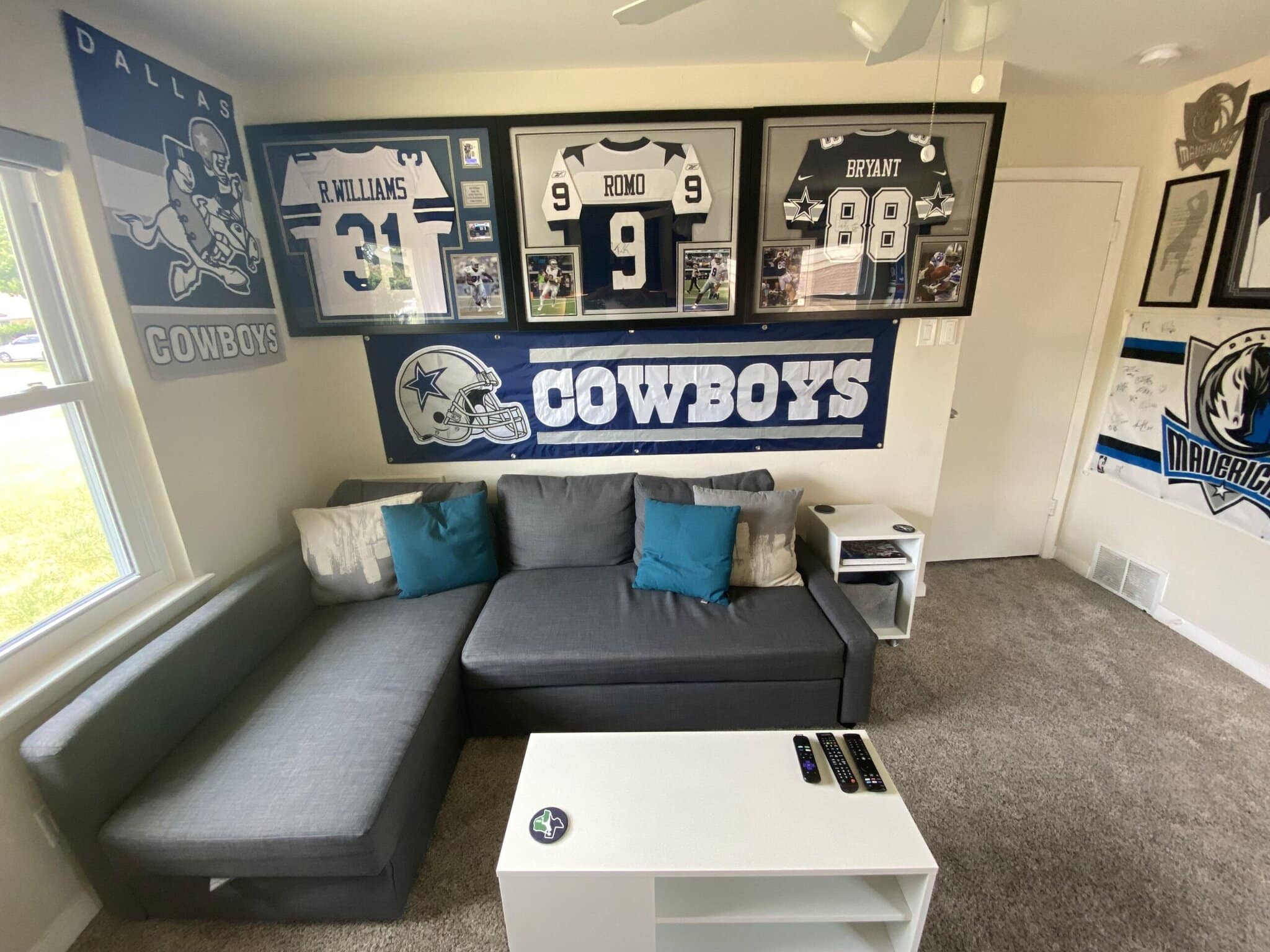 Dallas Cowboys memorabilia and decor featuring framed jerseys and team banners displayed in a sports-themed room.
