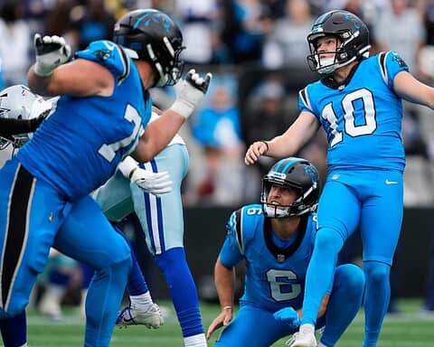 Vibrant image of football players from the Detroit Lions celebrating on the field during an NFL game, showcasing team spirit and athleticism; fans and stadium are visible in the background.