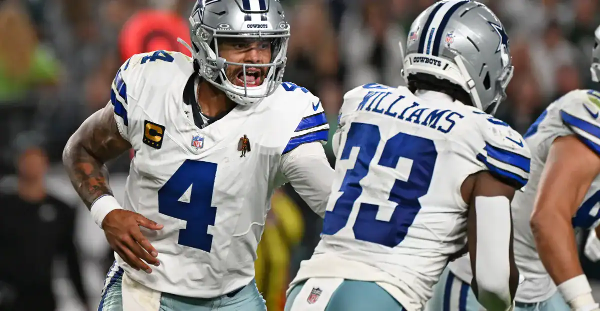 Dallas Cowboys quarterback Dak Prescott celebrating with teammates during a game, showcasing team spirit and leadership on the field.