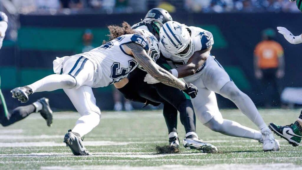 Tackle during an NFL game between Dallas Cowboys and Seattle Seahawks, highlighting key players in action on the football field.