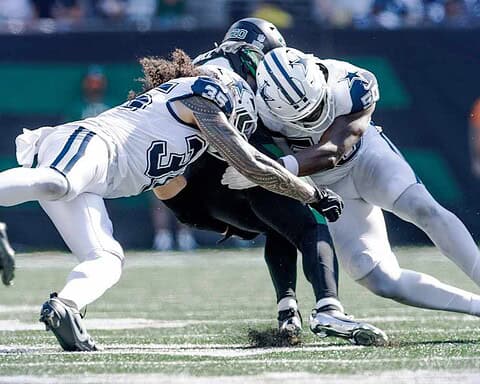 Tackle during an NFL game between Dallas Cowboys and Seattle Seahawks, highlighting key players in action on the football field.