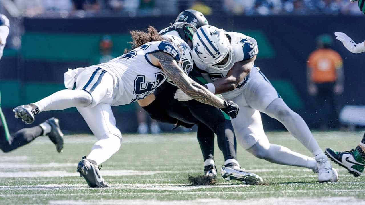 Tackle during an NFL game between Dallas Cowboys and Seattle Seahawks, highlighting key players in action on the football field.
