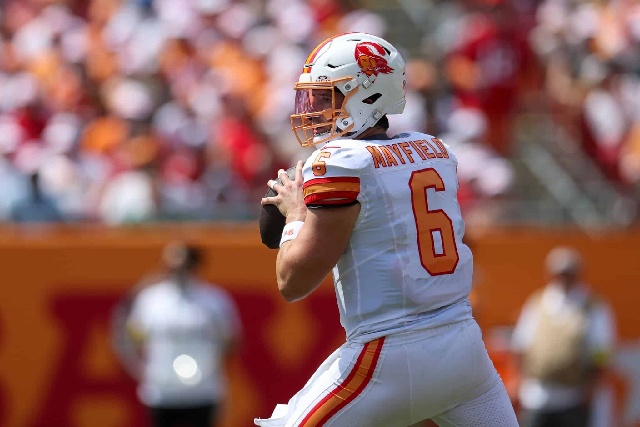 Quarterback Mayfield in action during an NFL game for the Kansas City Chiefs, wearing white jersey number 6 with team logo and helmet, preparing to throw a pass on the field.