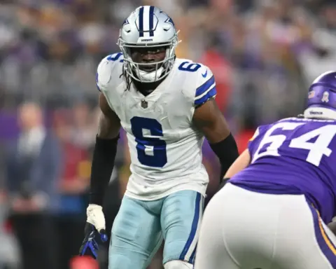 Dallas Cowboys football player in white jersey with blue accents, during an NFL game against Minnesota Vikings, close-up action shot, intense moment on the field, American football game.