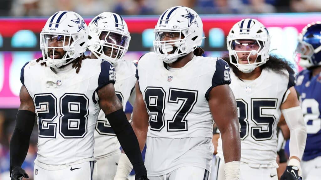 Dallas Cowboys football players in white uniforms on the field during a game.