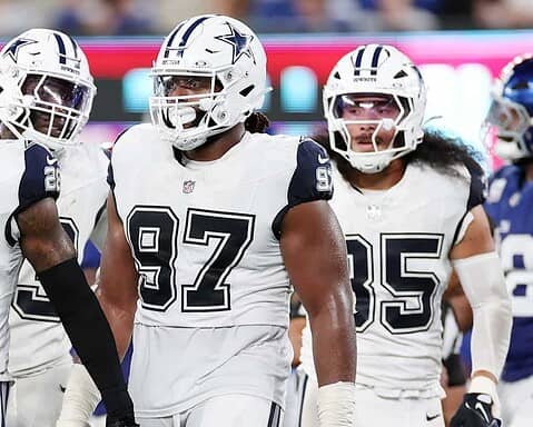 Dallas Cowboys football players in white uniforms on the field during a game.