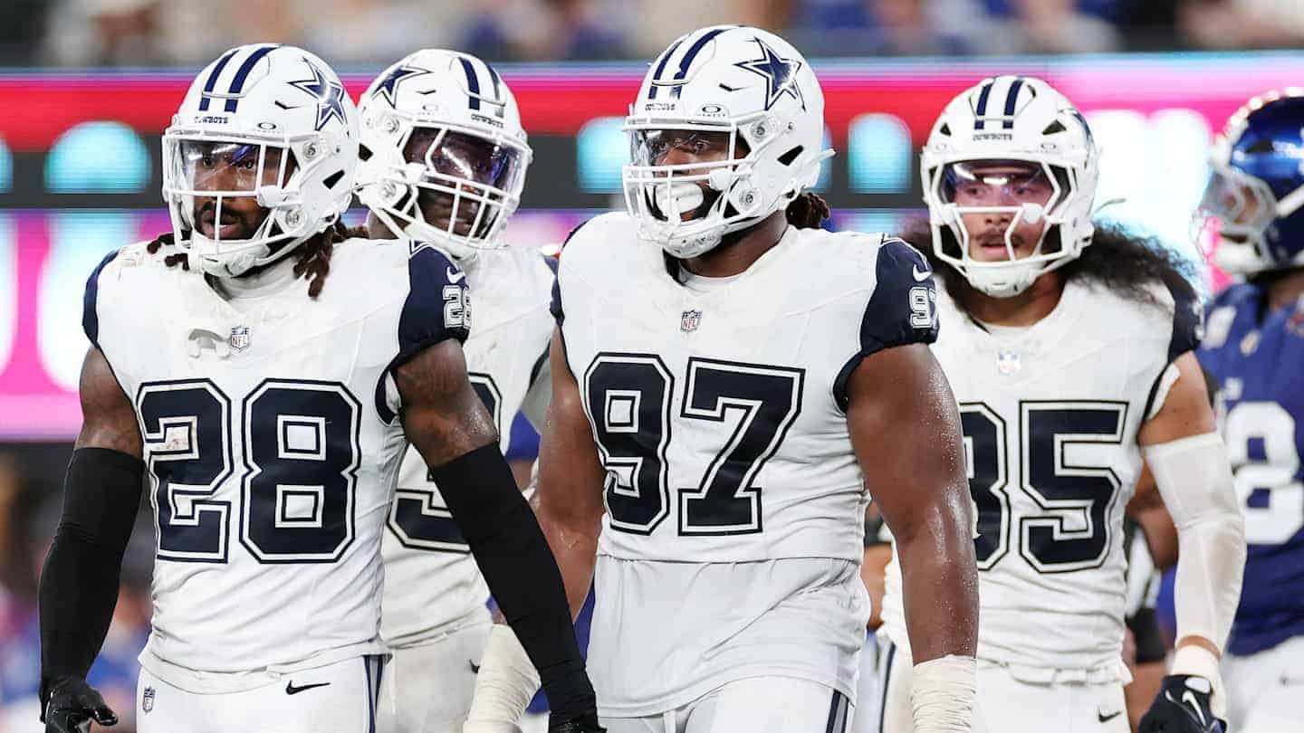 Dallas Cowboys football players in white uniforms on the field during a game.