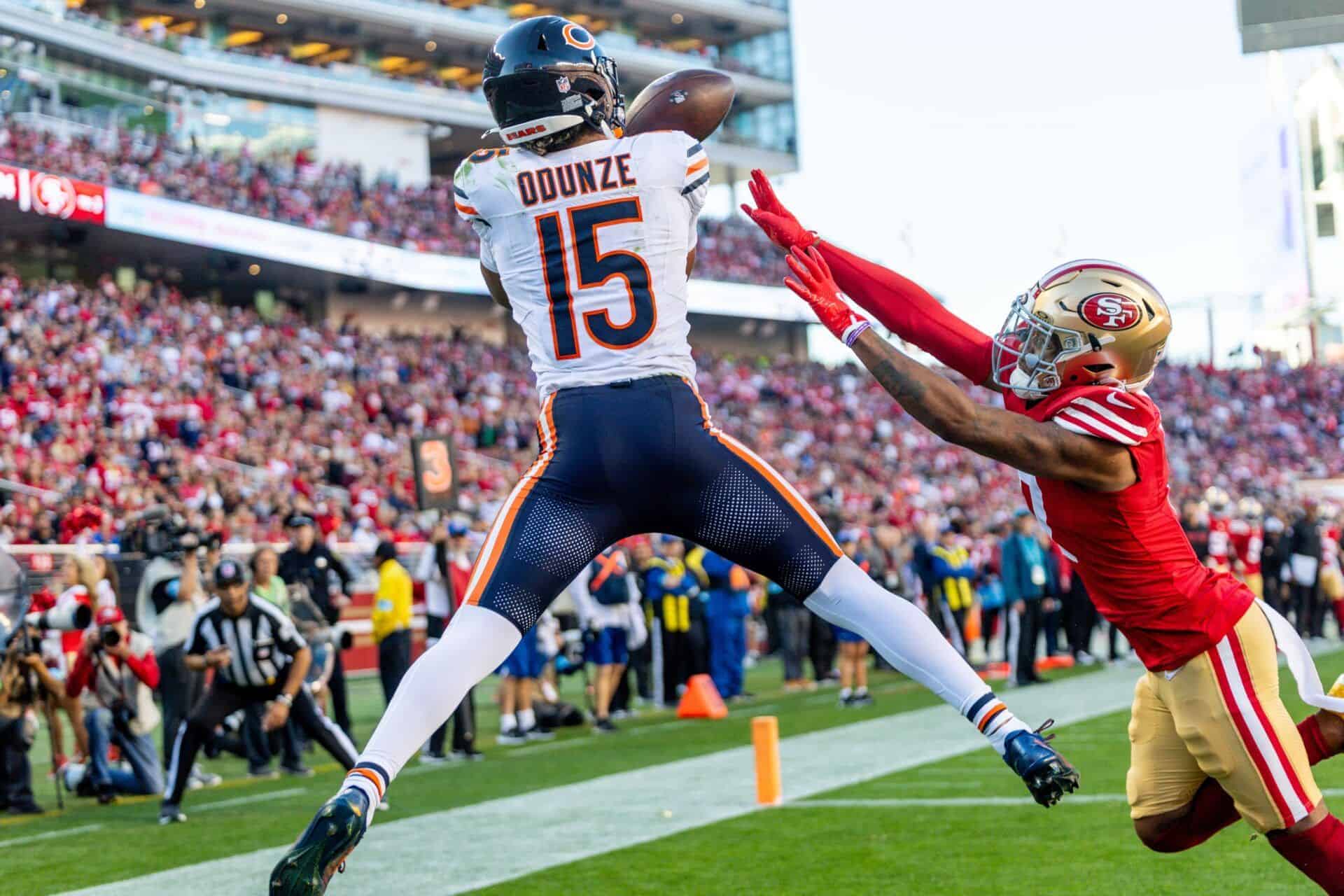 D.J. Moore of the Chicago Bears catching a football in the end zone during an NFC game against the San Francisco 49ers with a packed stadium crowd in the background.