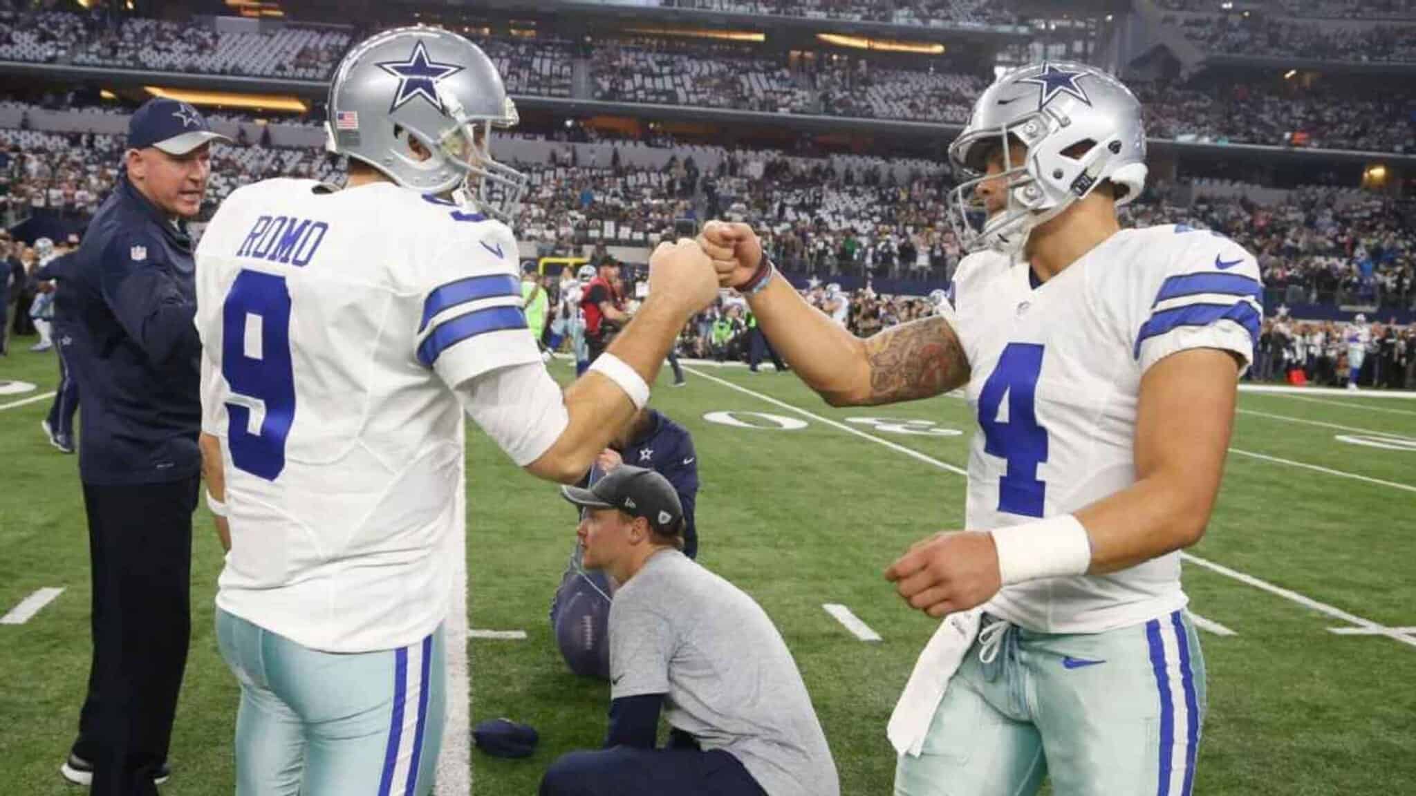 1. Dallas Cowboys football players fist bumping on the field during a game at AT&T Stadium.