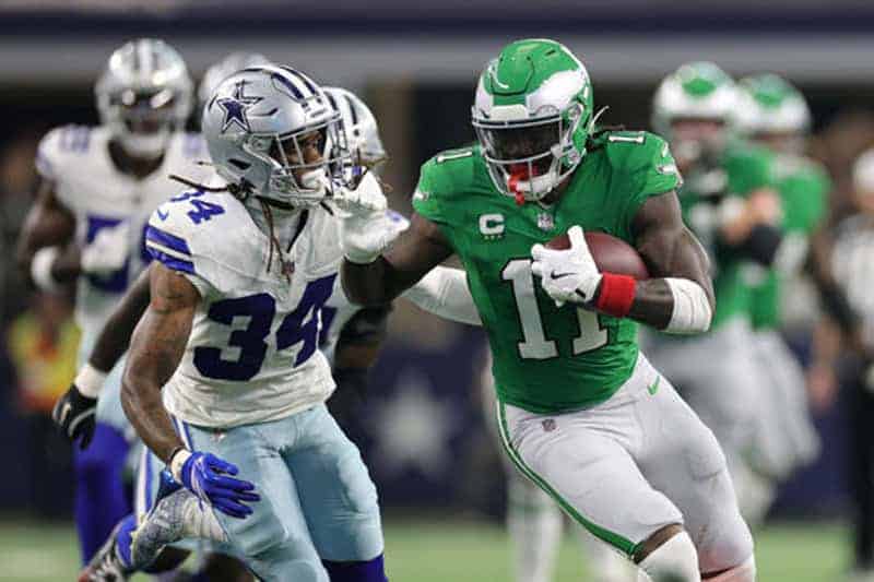 NFL game action featuring Dallas Cowboys and Miami Dolphins, showing football players in intense play, team jerseys, stadium background, inside access, Inside The Star sports coverage.
