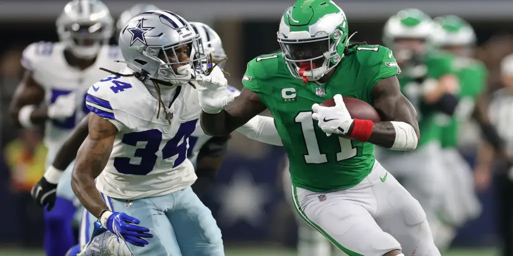 Dallas Cowboys and Philadelphia Eagles players in intense game, showcasing football tackling and rushing plays, with fans in background. High-energy NFL football scene capturing key moments on the field.