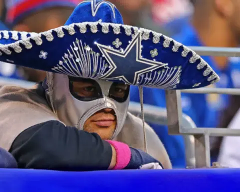 Fan wearing a Dallas Cowboys sombrero and mask at a sports game, showing team spirit and enthusiasm for Dallas Cowboys football games, capturing the vibrant fan culture and game-day excitement.