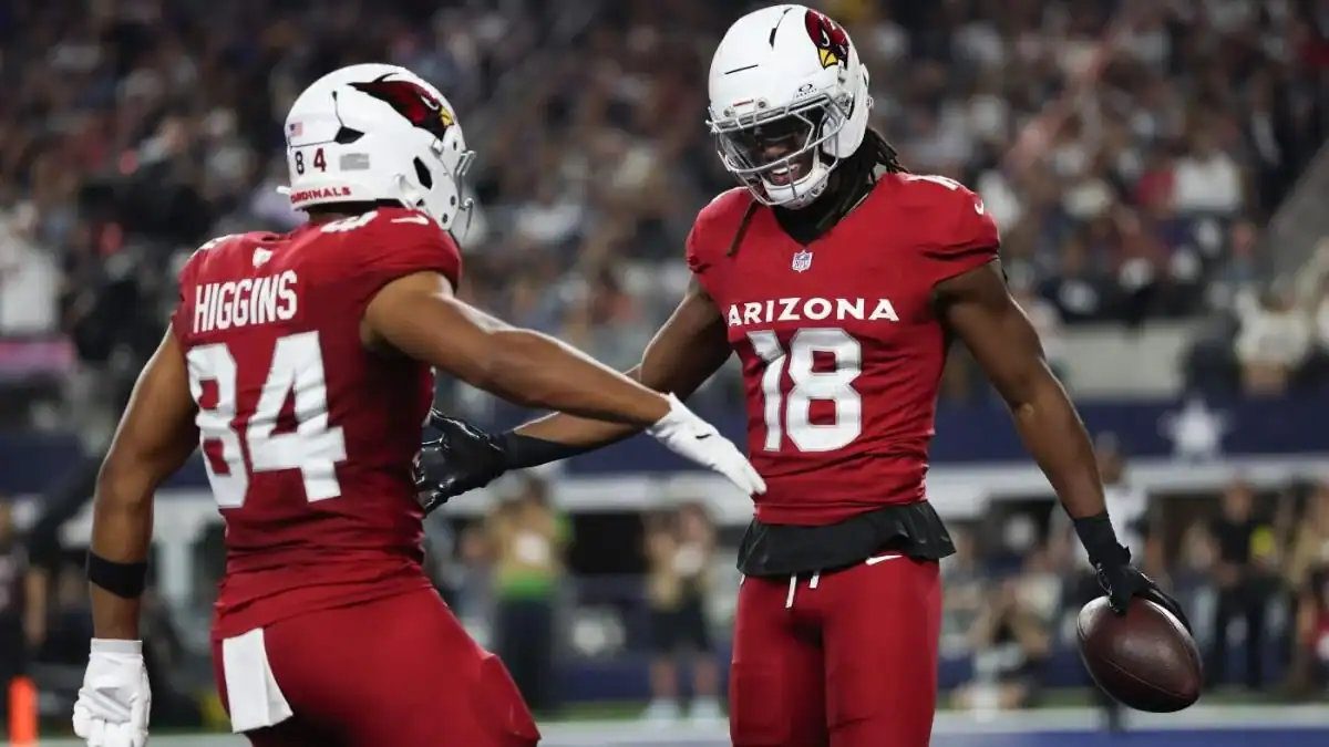Arizona Cardinals football players celebrating on the field during an NFL game, showcasing team spirit and excitement.
