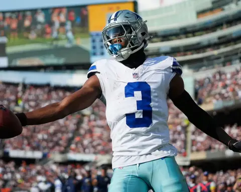 Dallas Cowboys football player holding the ball in stadium during game day, representing NFL football, athletic performance, and sports fan enthusiasm.
