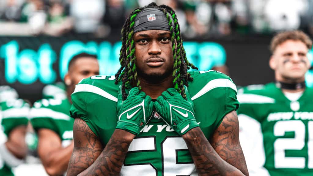 Fast-paced NFL football player from the Dallas Cowboys wearing green uniform, standing on the field during a game, showcasing team spirit and athletic prowess.