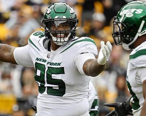 Celebrating a football touchdown with New York Jets player during a game, showcasing football action, team uniform, and energetic sportsmanship at an NFL game.