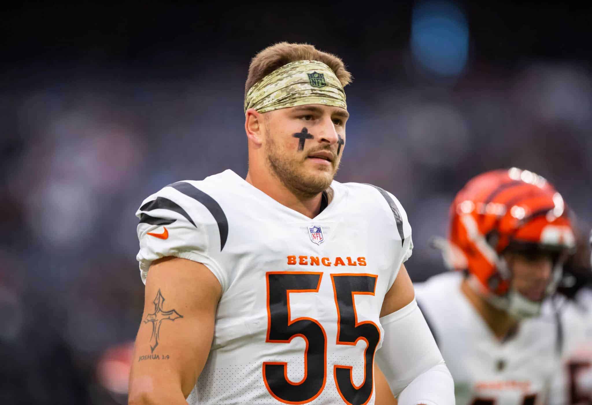 Baltimore Ravens football player wearing a white jersey with number 55, camo headband, and face paint, during a game on the field.
